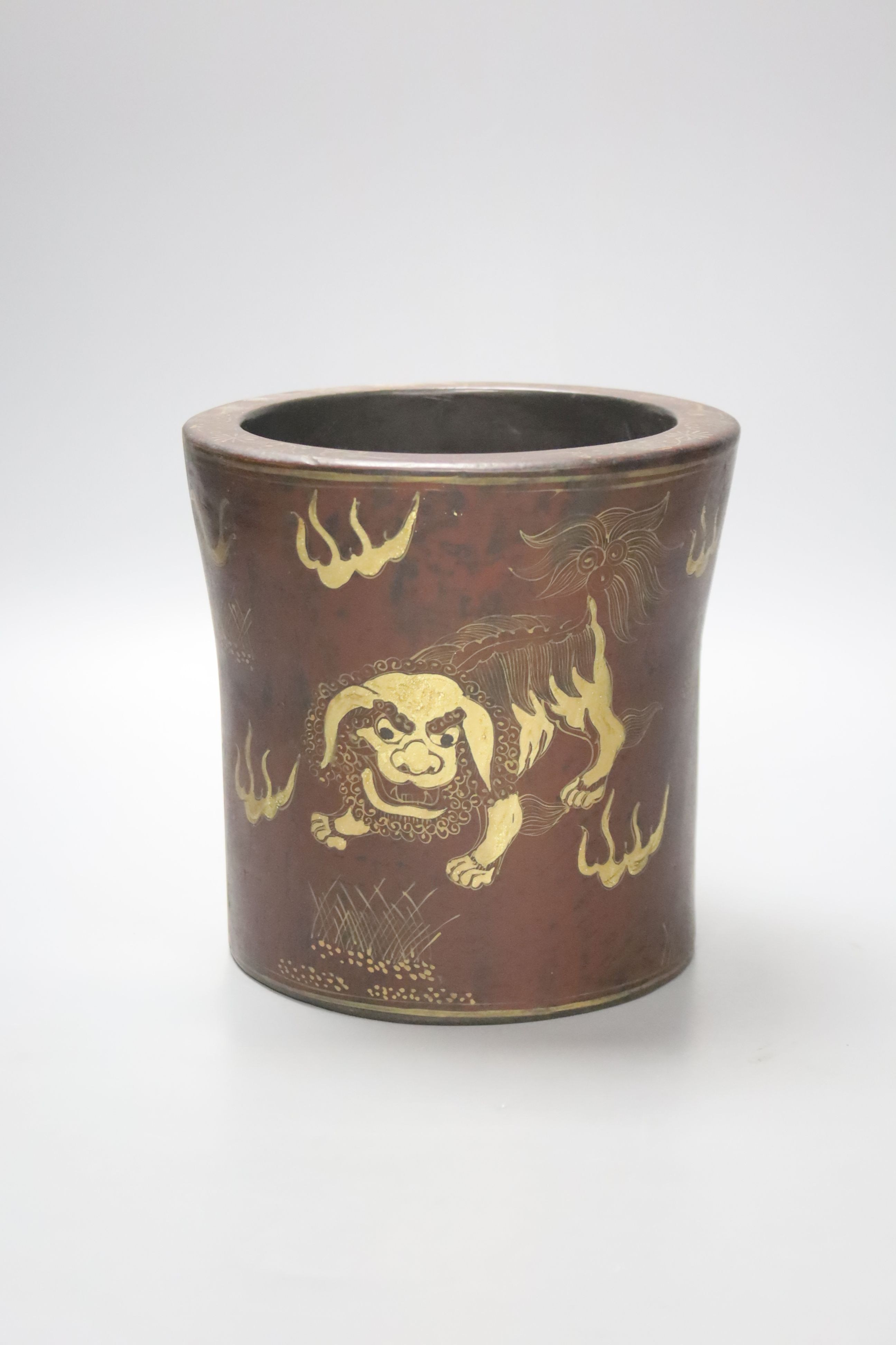 A Chinese lacquered brush pot / bitong, with gilt decoration of temple lions, character marks to underside, 16cm diameter 16cm high
